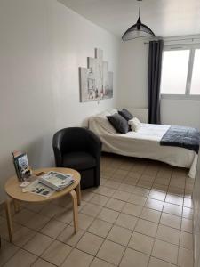 a bedroom with a bed and a chair and a table at Gites des Lavandières in Cour-Cheverny