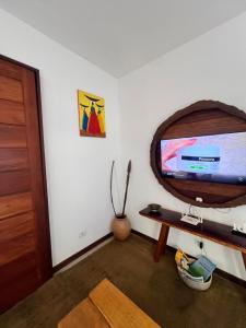 a living room with a flat screen tv on a wall at CASA SIMONI Trancoso in Trancoso