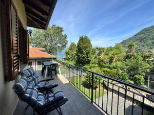a balcony with chairs and a table with a view at Villa Elvira fronte lago di Como by Gottschalk in Dervio