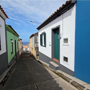 an alley with colorful buildings and a green door at SHR House in Porto Formoso