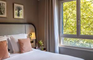 a bedroom with a bed and a large window at Warwick Reine Astrid - Lyon in Lyon +78 photos