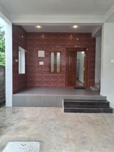 a room with a brick wall and a wooden door at Srivaari Residency Villa in Pondicherry