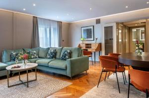 a living room with a green couch and a table at Warwick Reine Astrid - Lyon in Lyon