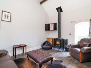 a living room with a couch and a fireplace at Clwyd Cottage in St Asaph