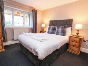 a bedroom with a large bed with two towels on it at Clwyd Cottage in St Asaph