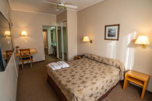 a hotel room with a bed and a bathroom at Comodoro Hotel in Comodoro Rivadavia +49 photos