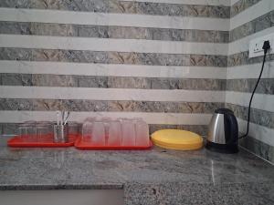 a counter top with glasses on a counter top with a sink at Srivaari Residency Villa in Pondicherry +12 photos