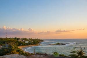 a view of a beach at sunset at Queens Beach Hotel in Tangalle