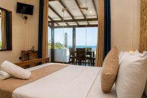 a bedroom with a bed and a view of the ocean at Queens Beach Hotel in Tangalle