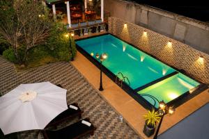 an overhead view of a swimming pool with an umbrella at Queens Beach Hotel in Tangalle +84 photos