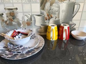 a counter top with a plate and two canisters at Aangan by Mom in Kalpa