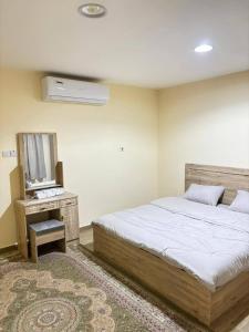 a bedroom with a bed and a television in it at thedesert08 in Ras al Khaimah