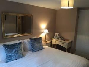 1 dormitorio con 1 cama blanca grande con almohadas azules en The Anchor Inn en Sutton Bridge