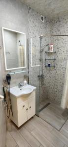 a bathroom with a sink and a shower with a mirror at H apartment in Yerevan +11 photos