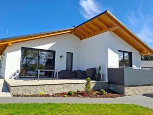 a white house with a couch and a patio at Mein Haus am See in Waldkirchen