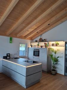 a kitchen with white counters and a wooden ceiling at Mein Haus am See in Waldkirchen