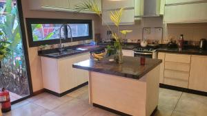 a kitchen with a island in the middle of it at Ombú Guests House in Puerto Iguazú