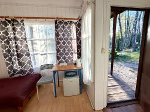 ein Zimmer mit einem Tisch und einem Fenster mit Vorhängen in der Unterkunft Nova Mazury in Święta Lipka