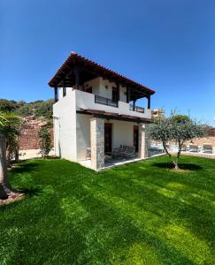 a house with a green lawn in front of it at Villas Roumeli in Roumelí