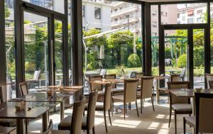 a restaurant with tables and chairs and large windows at Warwick Reine Astrid - Lyon in Lyon