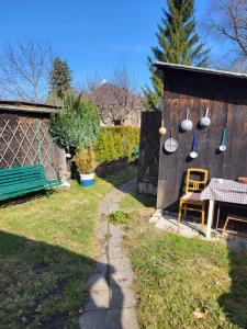 a garden with a bench and a wooden shed at Domek U hřiště in Hlinsko