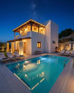 a villa with a swimming pool in front of a house at Villas Roumeli in Roumelí
