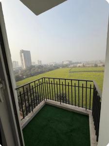 a balcony with a view of a green field at The Happy Nook Stays in Winsten Park Knowledge Park V in Noida