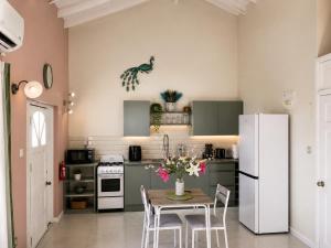 a kitchen with a table and a white refrigerator at Paradise Inn in Laborie