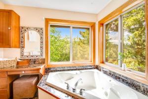 a bathroom with a large tub and two windows at Teanaway River Lodge in Cle Elum +54 photos