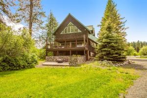 a large wooden house with a tree in front of it at Teanaway River Lodge in Cle Elum