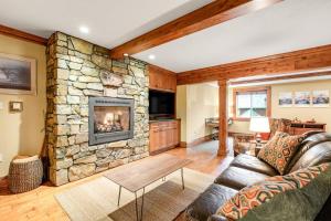 a living room with a couch and a stone fireplace at Teanaway River Lodge in Cle Elum