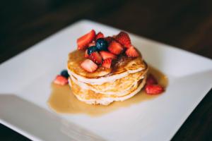 a stack of pancakes with strawberries and blueberries on a plate at Donegal Manor in Donegal +17 photos