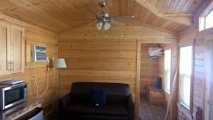 a living room with a couch and a ceiling fan at Lake Minden Camping Resort Cottage 1 in Nicolaus