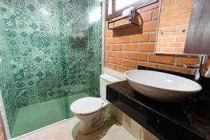 a bathroom with a sink and a toilet and a shower at Pousada Casarão Gastehaus in Pomerode