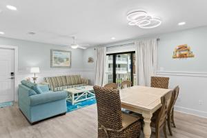 a dining room and living room with a table and a couch at VitaminSeaGrove in Santa Rosa Beach