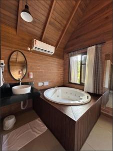 a large bathroom with a large tub and a mirror at Pousada Casarão Gastehaus in Pomerode