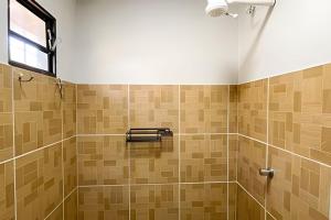 a bathroom with a shower and a window at Chalé Prainha com Cozinha - Valle das Pedras in Sao Jorge