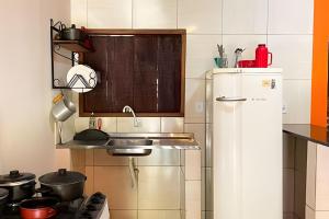 a small kitchen with a sink and a refrigerator at Chalé Prainha com Cozinha - Valle das Pedras in Sao Jorge +29 photos