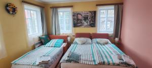 two beds in a room with two windows at Jiřetínská chaloupka in Jiřetín pod Jedlovou +76 photos