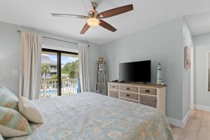 a bedroom with a bed and a flat screen tv at VitaminSeaGrove in Santa Rosa Beach