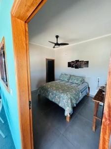 a bedroom with a bed and a ceiling fan at Pouso Canastra - Chalés in São João Batista do Glória