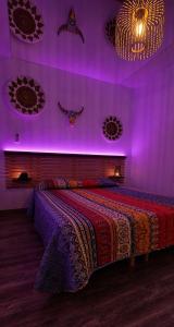 a bedroom with a large bed with purple lights at Maison Plus Belle La Nuit avec jacuzzi et jardin privé clim in Allauch