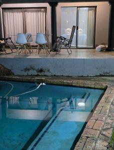 a group of chairs and a swimming pool at Mgwenya Capsule Hotel in Nelspruit