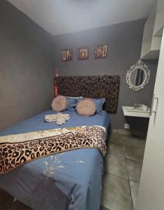 a bedroom with a bed with a leopard print blanket at Mgwenya Capsule Hotel in Nelspruit