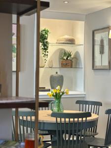 a dining room table with a vase of flowers on it at No 3 Chapel Row in Bakewell
