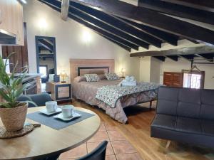 a bedroom with a bed and a table and chairs at Hostal El Rincón del Trillo in La Alberca +52 photos