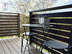 a table and two chairs on a deck at Lilac room in Ozolnieki