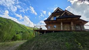 a wooden cabin on a hill with a blue sky at Sarnia CHATA in Brenna