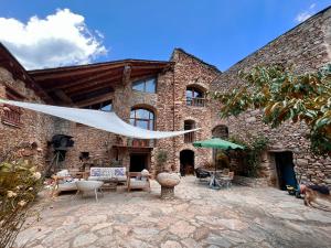 a large brick building with a patio with a dog at Cal David Estamariu in Estamariu