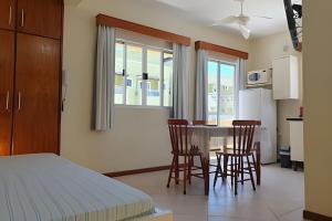 a bedroom with a bed and a table and chairs at Pousada Acapulco in Bombinhas